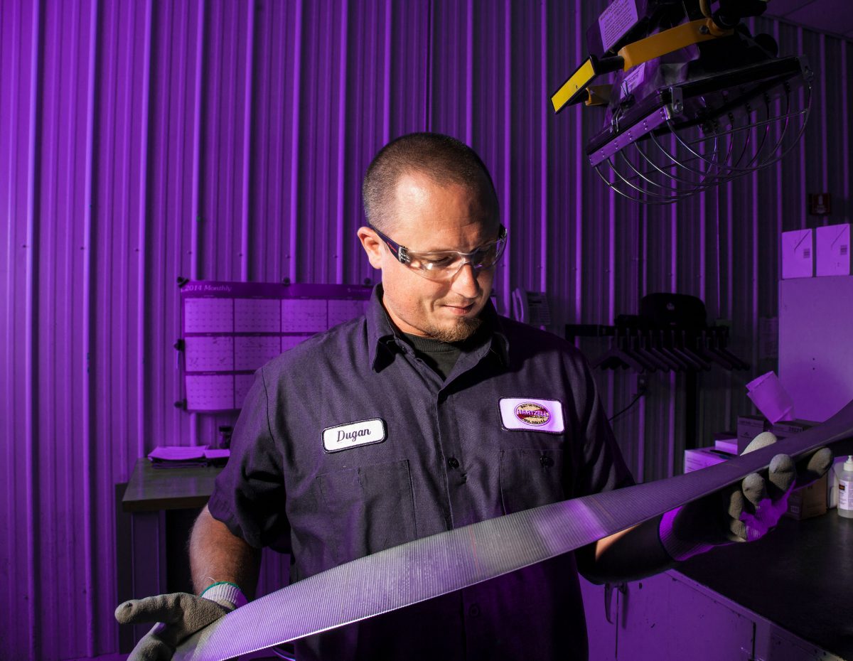 Hartzell employee holding propeller blade in factory