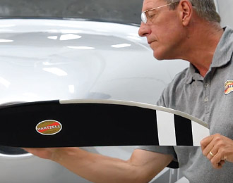 Hartzell Propeller technician Kevin Ryan examining black and white Hartzell propeller blade